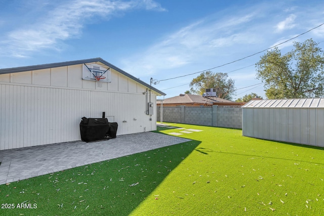 view of yard with a patio area and a storage unit