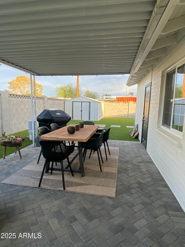 view of patio / terrace with a storage unit and a grill