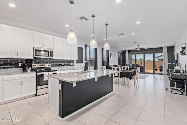 1005 W Lincoln Ave, Coolidge, AZ 85128 - kitchen featuring stainless steel appliances, a sink, ceiling fan, backsplash, and light stone countertops