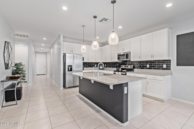 1005 W Lincoln Ave, Coolidge, AZ 85128 - kitchen with stainless steel appliances, a sink, tasteful backsplash, light tile patterned flooring, and white cabinets