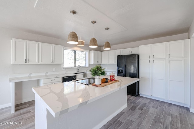 kitchen featuring white cabinetry, sink, hanging light fixtures, a center island, and black appliances