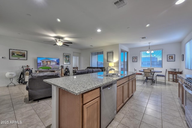 kitchen with a kitchen island with sink, sink, stainless steel appliances, and light tile patterned flooring