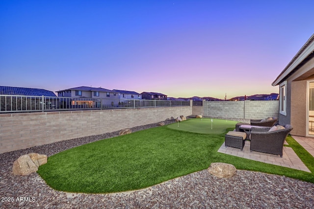 yard at dusk featuring a patio