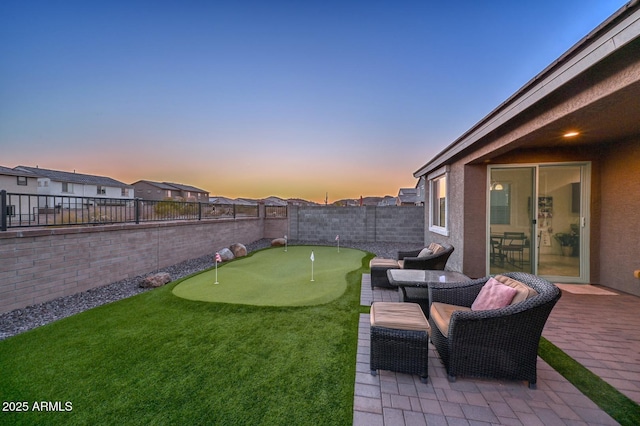 yard at dusk featuring a patio