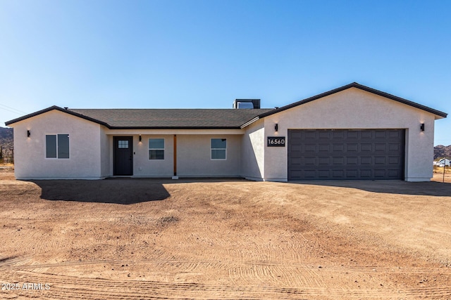 ranch-style home with driveway, an attached garage, and stucco siding