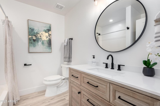 full bathroom featuring curtained shower, toilet, wood finished floors, vanity, and visible vents