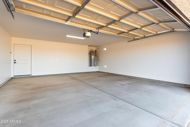 garage featuring baseboards, a garage door opener, and electric water heater