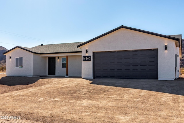 single story home with driveway, a shingled roof, an attached garage, and stucco siding