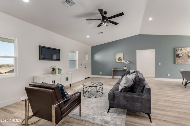 living area featuring lofted ceiling, light wood-type flooring, visible vents, and baseboards