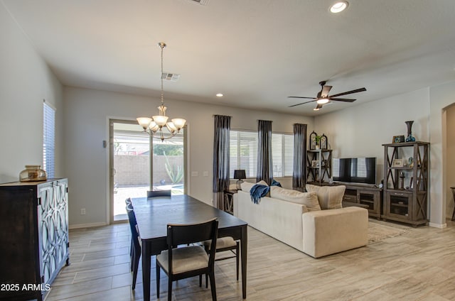 dining area featuring ceiling fan with notable chandelier