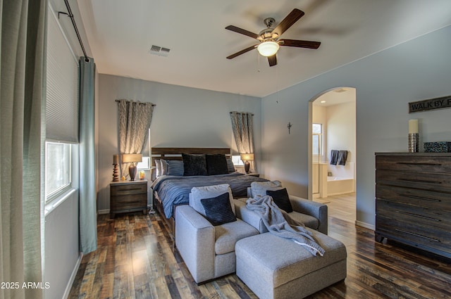 bedroom with ensuite bath, ceiling fan, and dark hardwood / wood-style flooring