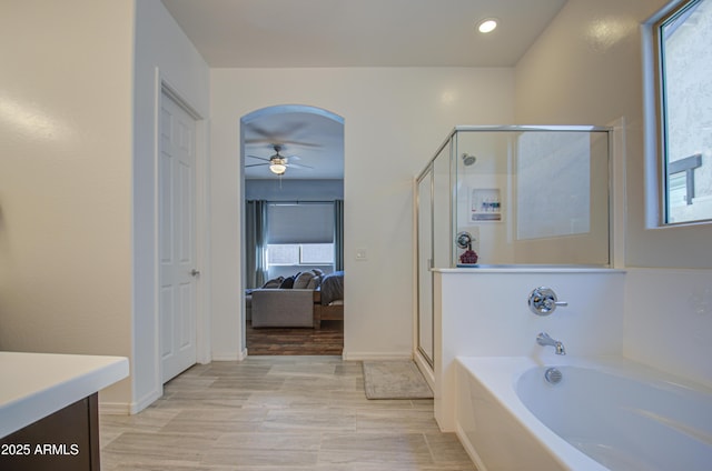 bathroom with plus walk in shower, ceiling fan, and vanity