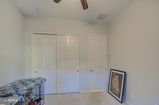 unfurnished bedroom featuring ceiling fan, light colored carpet, and a closet