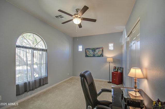 carpeted office space featuring ceiling fan