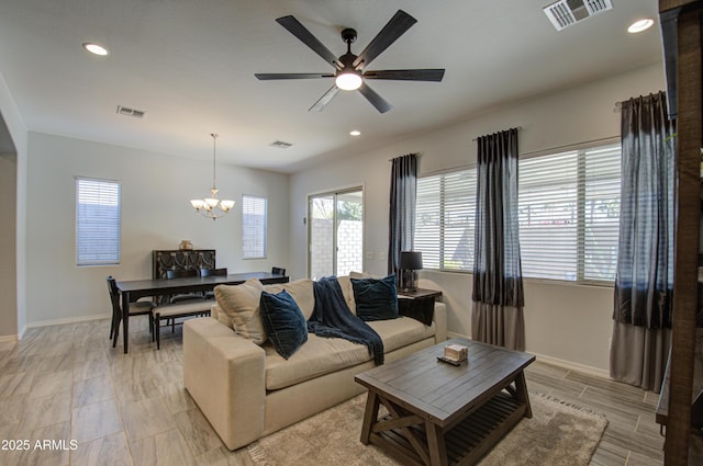 living room featuring ceiling fan with notable chandelier