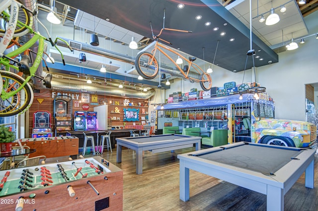 playroom with a towering ceiling, hardwood / wood-style flooring, and billiards