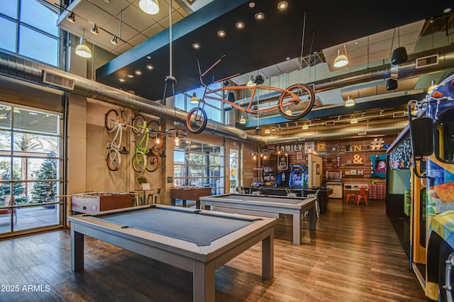 playroom with a towering ceiling, pool table, and hardwood / wood-style flooring