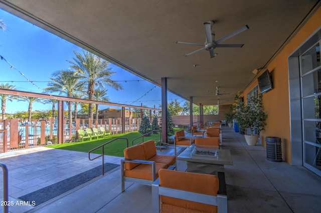 view of patio featuring ceiling fan and an outdoor living space with a fire pit