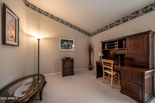 carpeted home office with vaulted ceiling