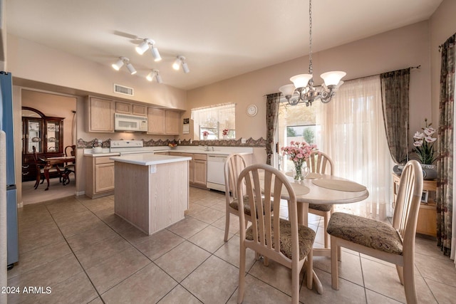 kitchen featuring decorative light fixtures, a chandelier, track lighting, a center island, and white appliances