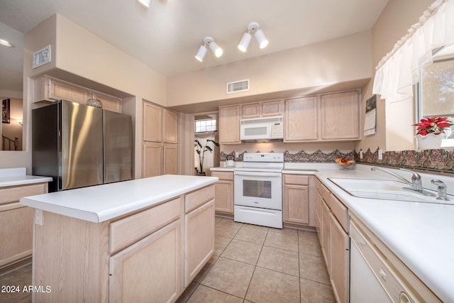 kitchen with light tile flooring, white appliances, light brown cabinets, sink, and a center island