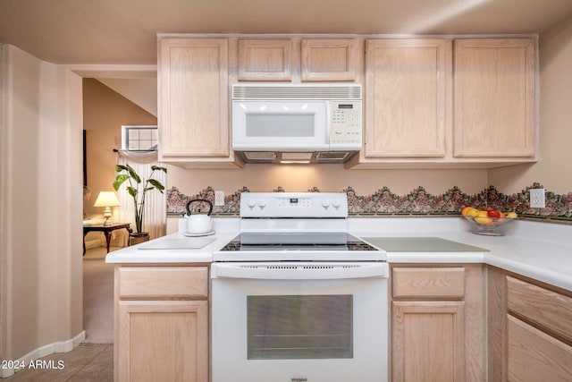 kitchen with light brown cabinetry and white appliances