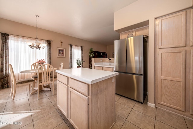 kitchen featuring light tile floors, hanging light fixtures, stainless steel refrigerator, an inviting chandelier, and a center island