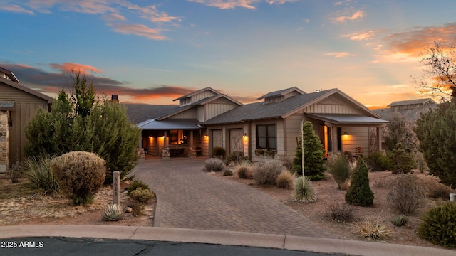 view of front of home featuring board and batten siding, decorative driveway, and an attached garage