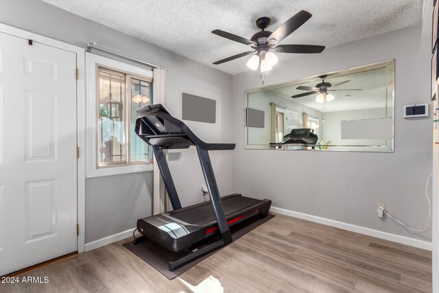 workout room with ceiling fan, a textured ceiling, and light wood-type flooring