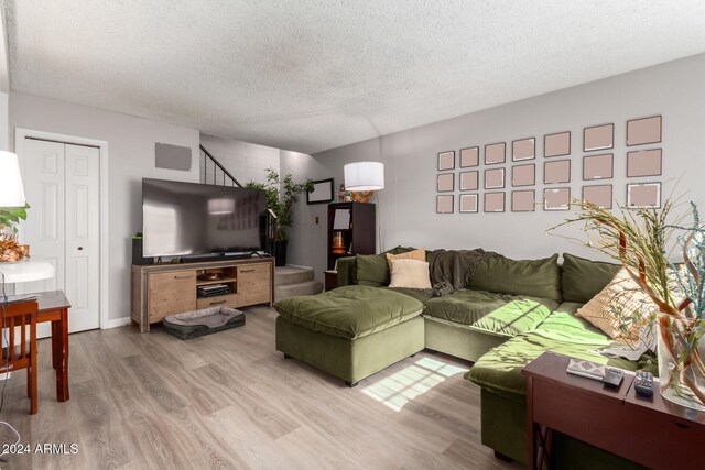 living room with light wood-type flooring and a textured ceiling