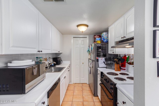 kitchen with tasteful backsplash, stainless steel appliances, light tile patterned floors, sink, and white cabinets