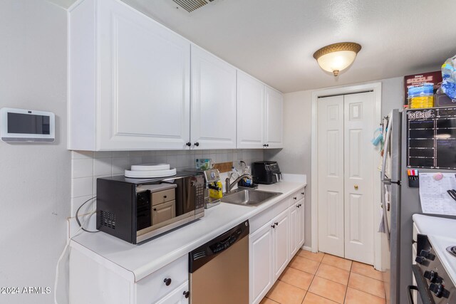 kitchen with white cabinets, sink, backsplash, and appliances with stainless steel finishes