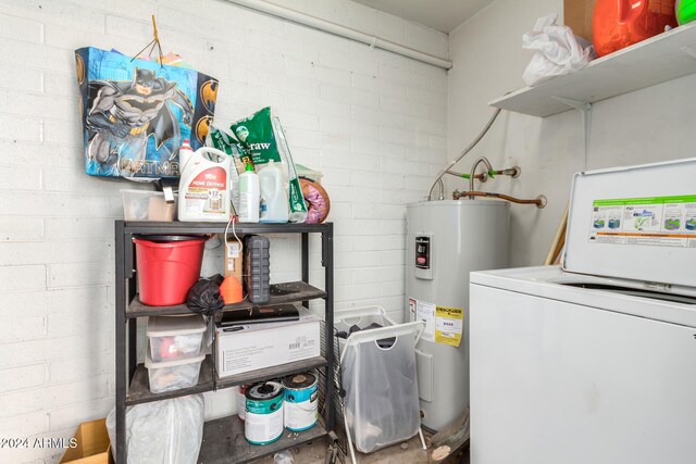 washroom with water heater and washer / dryer