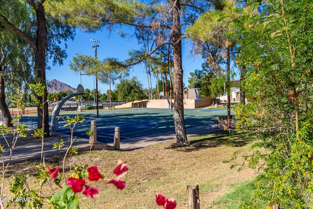 view of sport court featuring basketball hoop and a mountain view