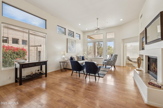 interior space with light hardwood / wood-style flooring, ceiling fan, and a high ceiling