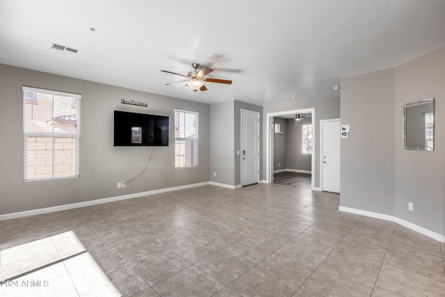 spare room with ceiling fan and light tile patterned flooring