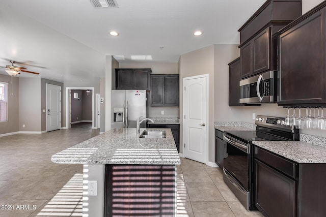 kitchen with a kitchen island with sink, sink, ceiling fan, appliances with stainless steel finishes, and light tile patterned flooring