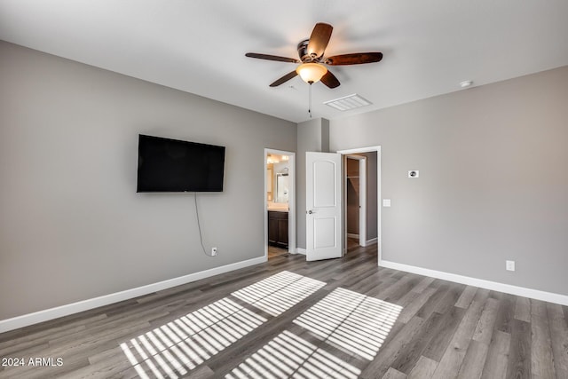 unfurnished bedroom featuring hardwood / wood-style flooring, ceiling fan, and ensuite bath