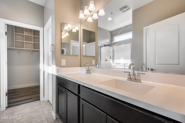 bathroom with tile patterned floors, vanity, and an enclosed shower