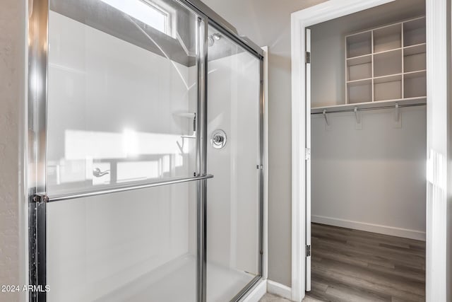 bathroom featuring an enclosed shower and hardwood / wood-style flooring