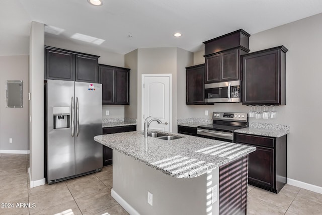 kitchen featuring a kitchen island with sink, sink, light tile patterned flooring, and appliances with stainless steel finishes