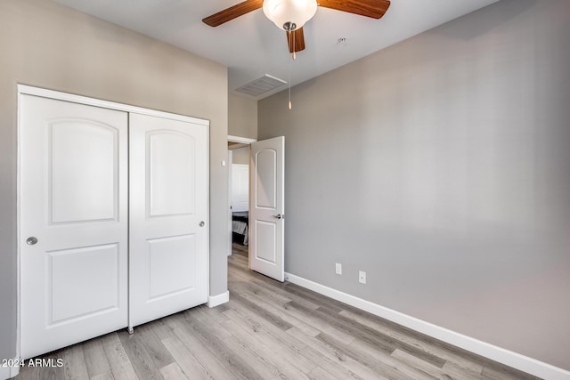 unfurnished bedroom with light hardwood / wood-style flooring, a closet, and ceiling fan