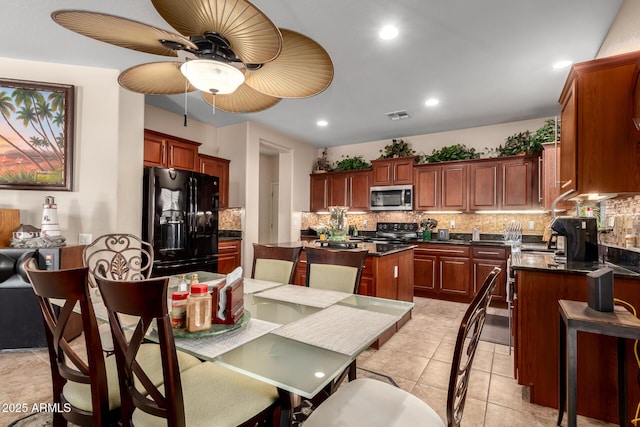 kitchen featuring tasteful backsplash, recessed lighting, visible vents, a kitchen island, and black appliances