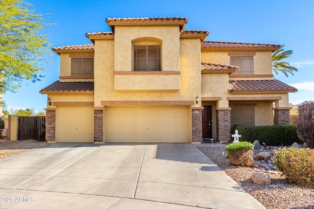 mediterranean / spanish home featuring an attached garage, fence, driveway, stone siding, and stucco siding