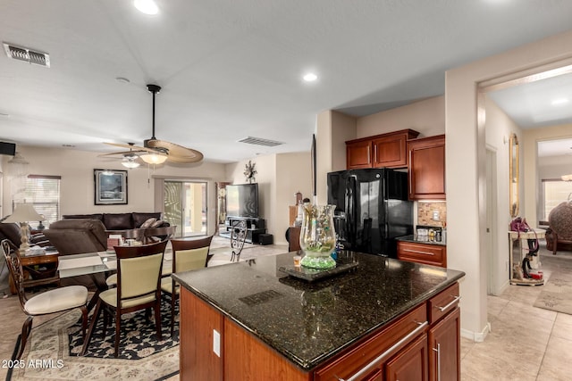 kitchen with a center island, open floor plan, visible vents, and black fridge with ice dispenser