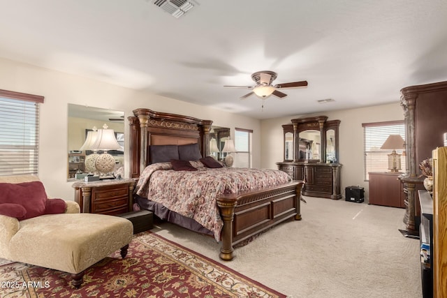 bedroom featuring a ceiling fan, light colored carpet, and visible vents