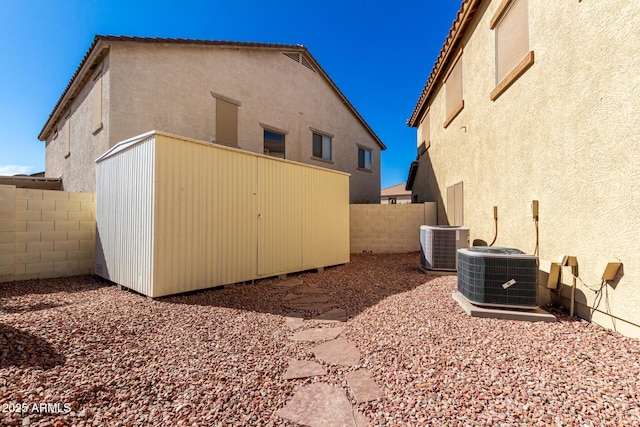 back of house featuring stucco siding, a fenced backyard, and central air condition unit