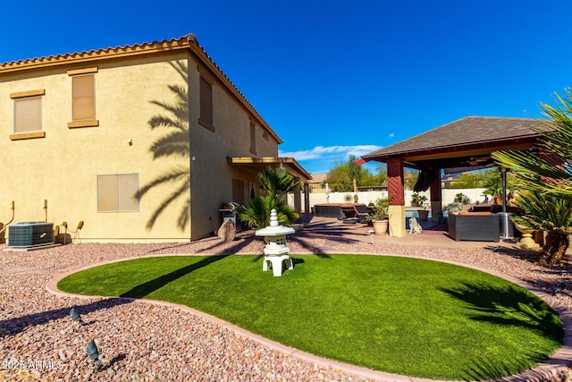 view of yard with a patio, a ceiling fan, central AC, fence, and an outdoor living space