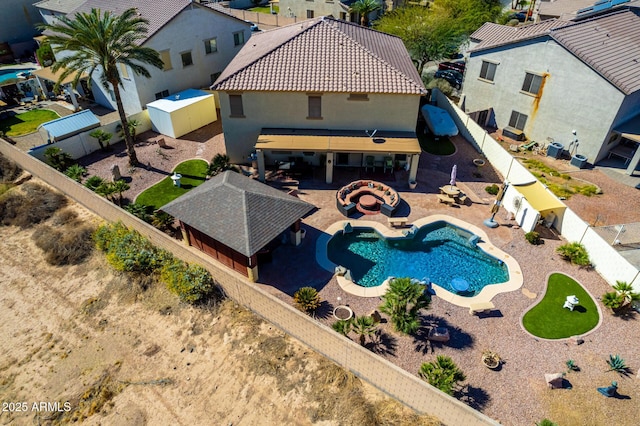 view of swimming pool with a patio area, a fenced backyard, an outdoor structure, and a shed