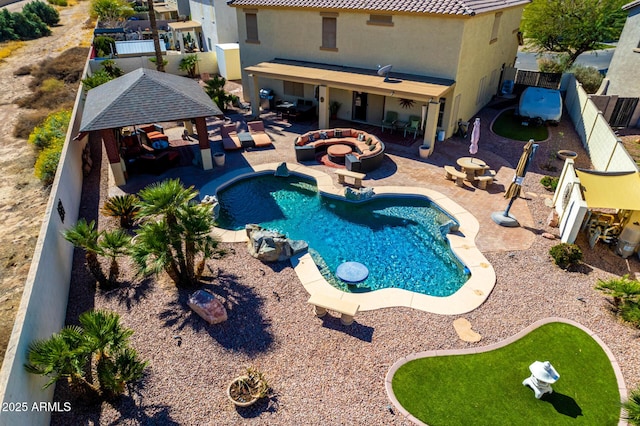 view of swimming pool featuring a gazebo, an outdoor fire pit, a patio area, and a fenced backyard